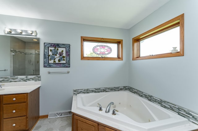 1218 6th St NW, Dodge Center, MN 55927 - bathroom featuring a stall shower, a tub with jets, vanity, and baseboards