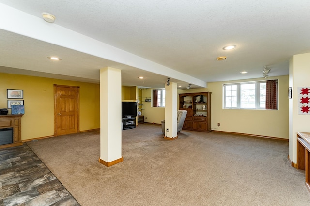 1218 6th St NW, Dodge Center, MN 55927 - below grade area featuring plenty of natural light, baseboards, recessed lighting, carpet flooring, and a glass covered fireplace