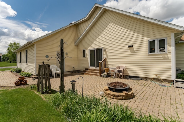 1218 6th St NW, Dodge Center, MN 55927 - rear view of house featuring a fire pit, a patio area, and entry steps