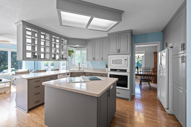1902 Duck Pond Dr W, Saint Paul, MN 55118 - kitchen featuring white appliances, gray cabinets, a peninsula, a textured ceiling, and light wood-style floors