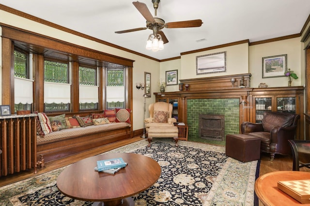 880 Fairmount Ave, Saint Paul, MN 55105 - living room with wood finished floors, a tiled fireplace, crown molding, and a ceiling fan