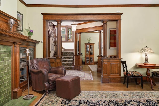 880 Fairmount Ave, Saint Paul, MN 55105 - living area featuring ornate columns, wood finished floors, stairs, and crown molding