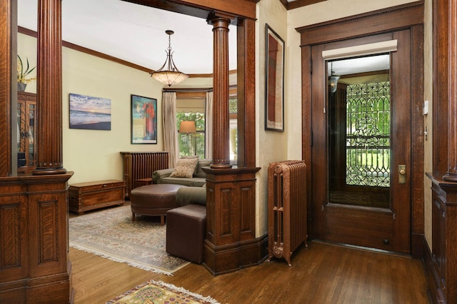 880 Fairmount Ave, Saint Paul, MN 55105 - foyer with radiator heating unit, dark wood-type flooring, crown molding, and decorative columns