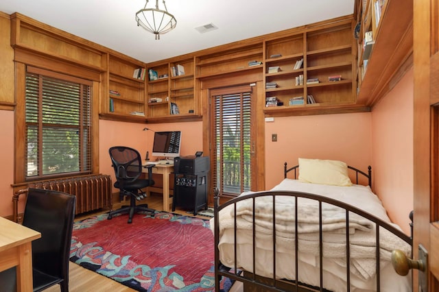 880 Fairmount Ave, Saint Paul, MN 55105 - bedroom with radiator heating unit, a desk, and wood finished floors