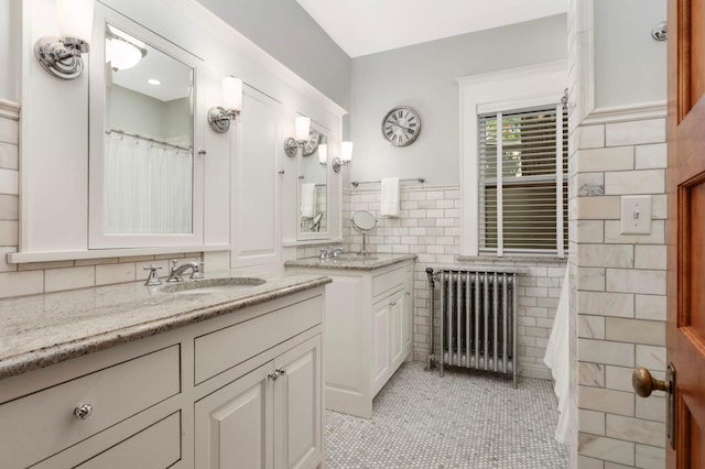 880 Fairmount Ave, Saint Paul, MN 55105 - bathroom featuring radiator, tile walls, two vanities, tile patterned flooring, and a wainscoted wall
