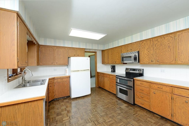 507 24th Ave S, Fargo, ND 58103 - kitchen featuring stainless steel appliances, light countertops, backsplash, and brown cabinetry