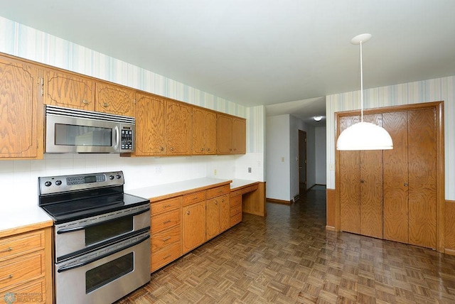 507 24th Ave S, Fargo, ND 58103 - kitchen with appliances with stainless steel finishes, light countertops, brown cabinets, and decorative light fixtures