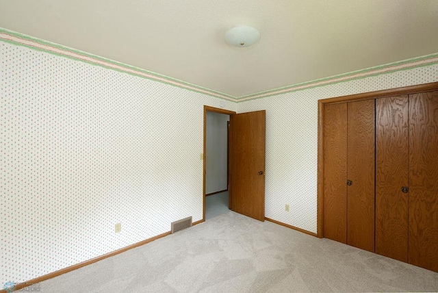 507 24th Ave S, Fargo, ND 58103 - unfurnished bedroom featuring a closet, light colored carpet, and wallpapered walls