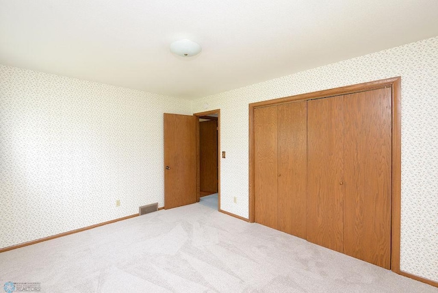 507 24th Ave S, Fargo, ND 58103 - unfurnished bedroom with wallpapered walls, a closet, and carpet floors