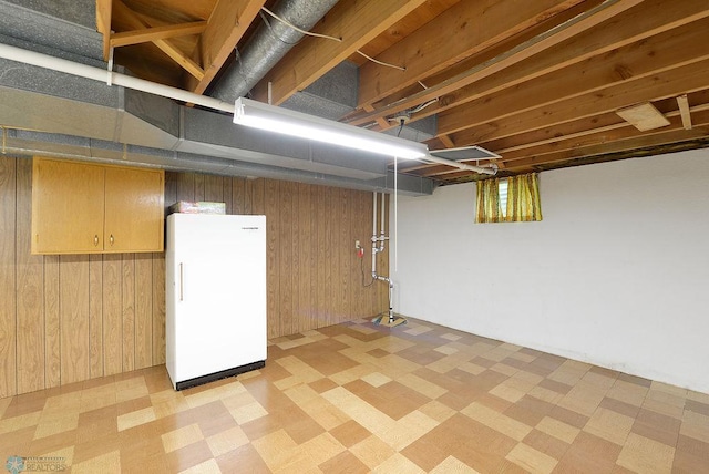 507 24th Ave S, Fargo, ND 58103 - below grade area featuring freestanding refrigerator, light floors, and wooden walls