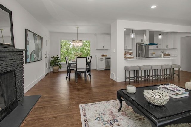 2307 Sherwood Cir, Bloomington, MN 55431 - living room with dark wood finished floors, a stone fireplace, recessed lighting, baseboards, and a chandelier