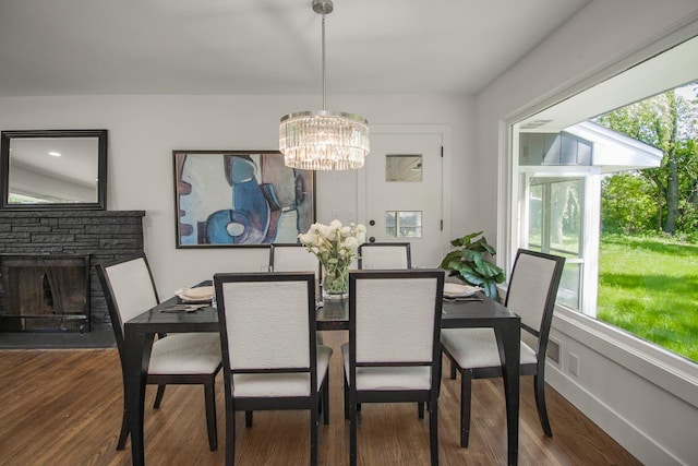 2307 Sherwood Cir, Bloomington, MN 55431 - dining space featuring a fireplace, a chandelier, wood finished floors, and baseboards