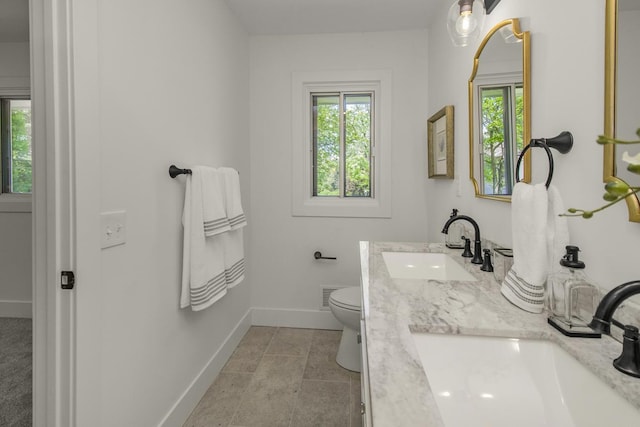 2307 Sherwood Cir, Bloomington, MN 55431 - bathroom with baseboards, double vanity, and toilet