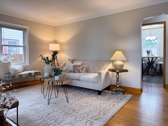 1759 Arlington Ave E, Saint Paul, MN 55106 - living area featuring wood finished floors, a chandelier, baseboards, and arched walkways