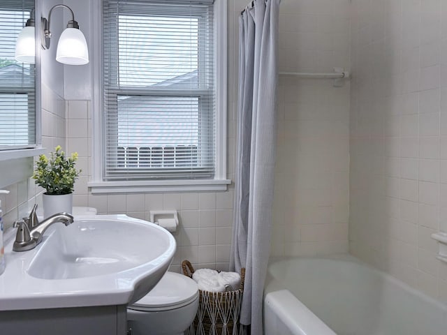 1759 Arlington Ave E, Saint Paul, MN 55106 - bathroom featuring toilet, vanity, shower / tub combo with curtain, and tile walls