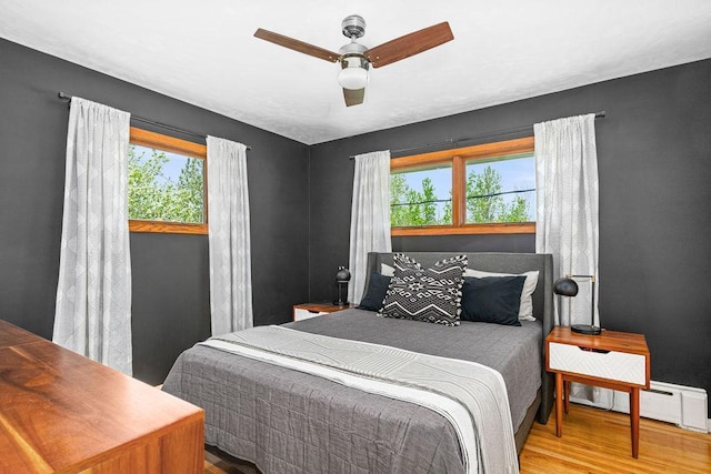 315 Pleasant View Rd, Duluth, MN 55803 - bedroom with multiple windows, wood finished floors, a baseboard heating unit, and ceiling fan