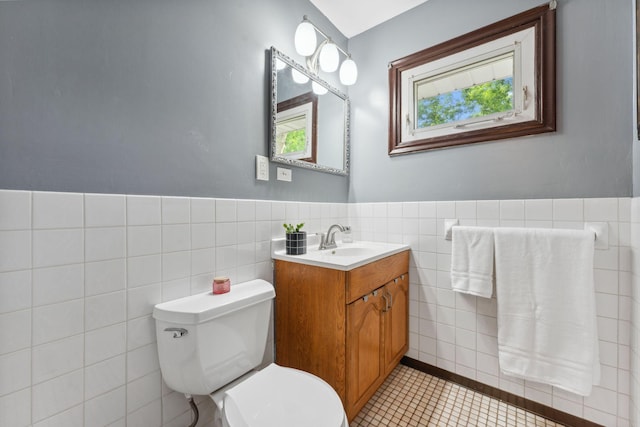 8400 Virginia Cir S, Saint Louis Park, MN 55426 - bathroom featuring tile walls, toilet, vanity, tile patterned floors, and a wainscoted wall