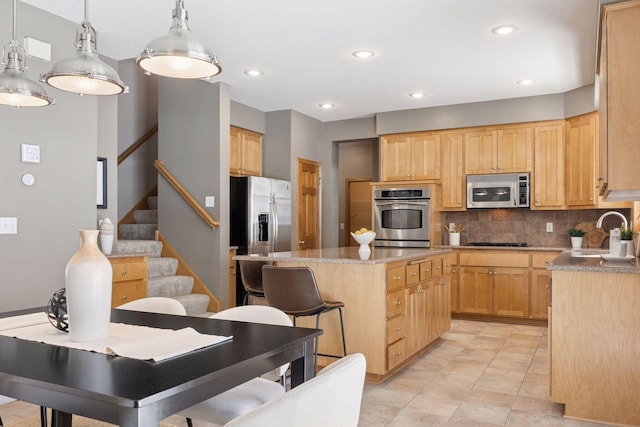 1496 Pinetree Trl, Eagan, MN 55122 - kitchen with appliances with stainless steel finishes, a center island, a sink, decorative backsplash, and decorative light fixtures