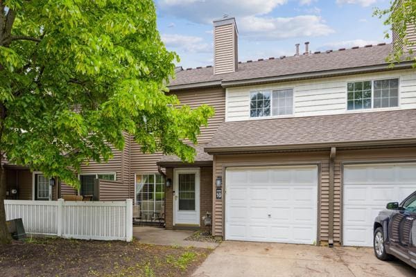 9955 Russell Ave N Unit 10, Brooklyn Park, MN 55444 - townhome / multi-family property featuring a chimney, a garage, concrete driveway, and a shingled roof