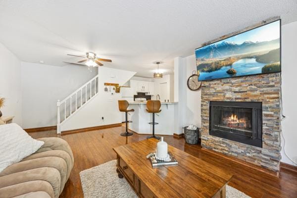 9955 Russell Ave N Unit 10, Brooklyn Park, MN 55444 - living room with stairway, baseboards, a fireplace, a ceiling fan, and wood finished floors