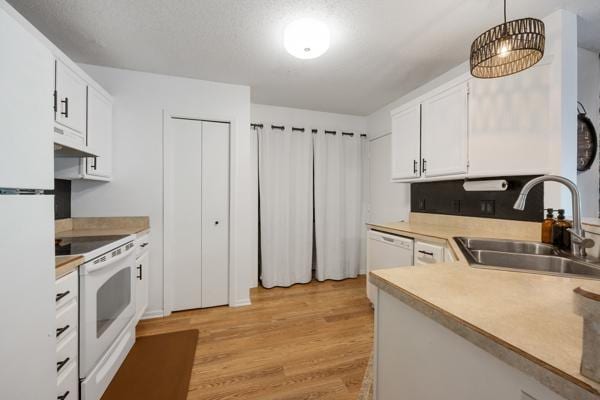 9955 Russell Ave N Unit 10, Brooklyn Park, MN 55444 - kitchen featuring a sink, white appliances, light wood-style floors, under cabinet range hood, and white cabinetry