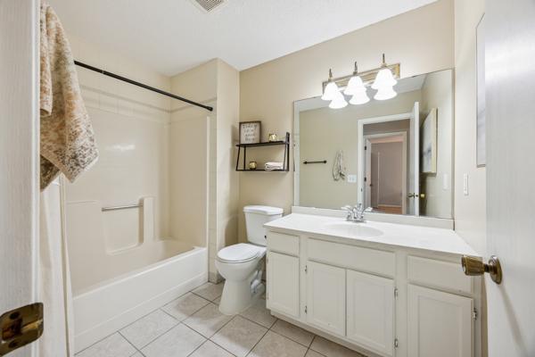 9955 Russell Ave N Unit 10, Brooklyn Park, MN 55444 - bathroom featuring tile patterned flooring, vanity, toilet, and bathtub / shower combination
