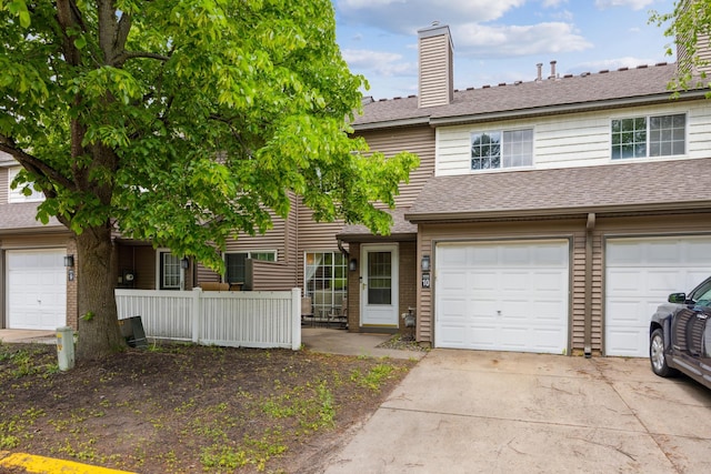 9955 Russell Ave N Unit 10, Brooklyn Park, MN 55444 - townhome / multi-family property with concrete driveway, a chimney, roof with shingles, and an attached garage