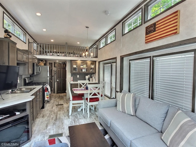 10255 Nevens Ave NW Unit 50, South Haven, MN 55382 - living area with light wood finished floors, a chandelier, healthy amount of natural light, recessed lighting, and a towering ceiling