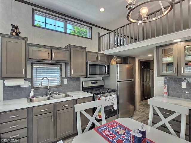 10255 Nevens Ave NW Unit 50, South Haven, MN 55382 - kitchen with appliances with stainless steel finishes, a sink, a towering ceiling, light countertops, and backsplash