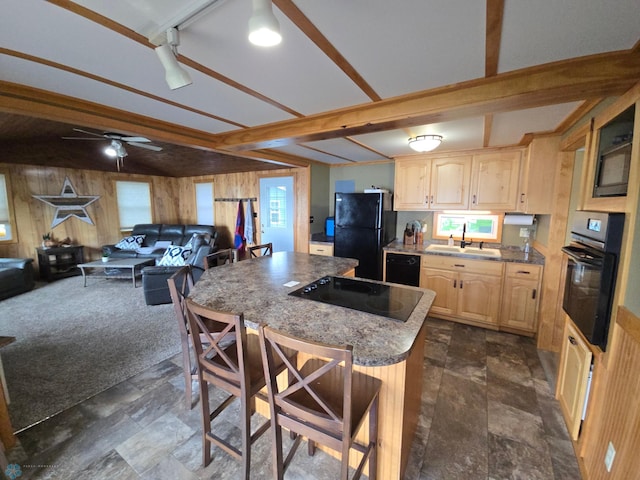 14768 Tradewinds Rd, Lake Eunice Twp, MN 56511 - kitchen with black appliances, light brown cabinetry, wood walls, a center island, and a breakfast bar area