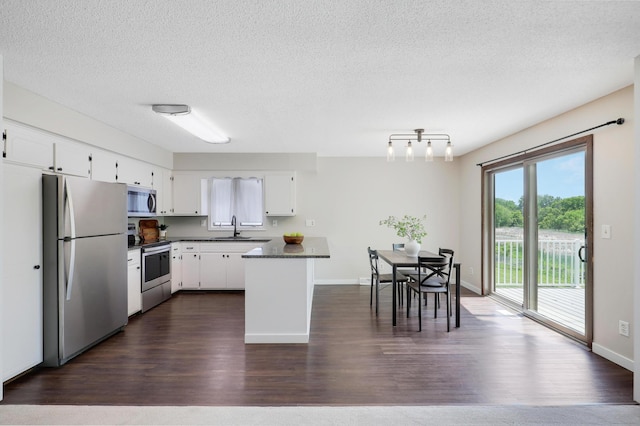 16503 Franklin Trl SE, Prior Lake, MN 55372 - kitchen featuring appliances with stainless steel finishes, dark countertops, a sink, white cabinetry, and dark wood-type flooring