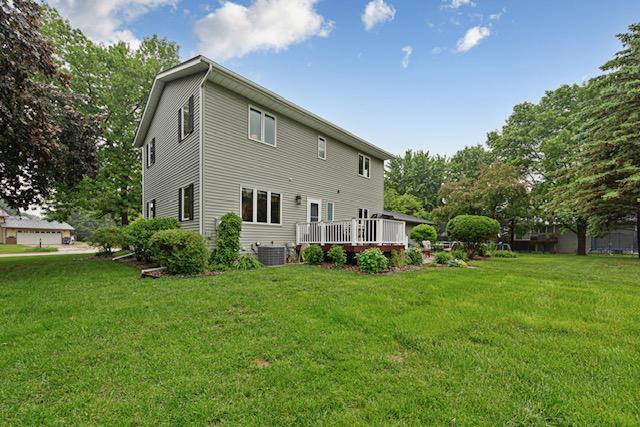 1525 21st Ave NW, Faribault, MN 55021 - rear view of property with a yard, a wooden deck, and central AC unit