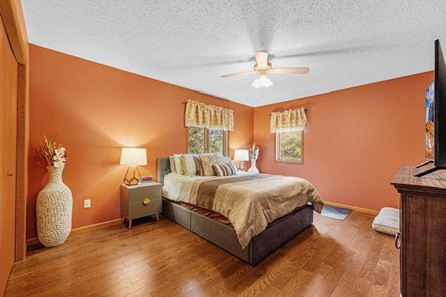 1525 21st Ave NW, Faribault, MN 55021 - bedroom featuring baseboards, wood finished floors, a textured ceiling, and ceiling fan