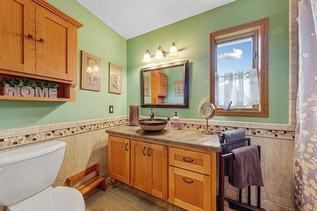 1525 21st Ave NW, Faribault, MN 55021 - bathroom with toilet, vanity, tile walls, and a wainscoted wall
