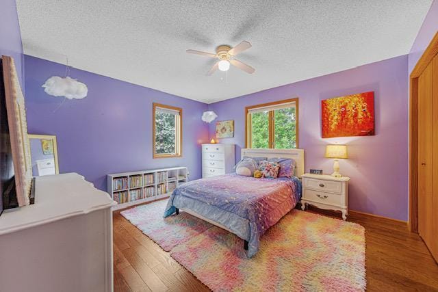 1525 21st Ave NW, Faribault, MN 55021 - bedroom with a textured ceiling, wood finished floors, a ceiling fan, and baseboards