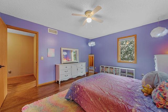 1525 21st Ave NW, Faribault, MN 55021 - bedroom with wood finished floors, a textured ceiling, baseboards, and ceiling fan