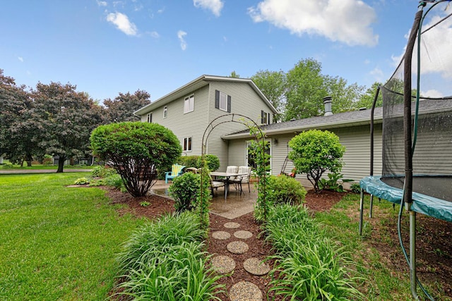1525 21st Ave NW, Faribault, MN 55021 - back of property with a trampoline, a patio area, and a lawn