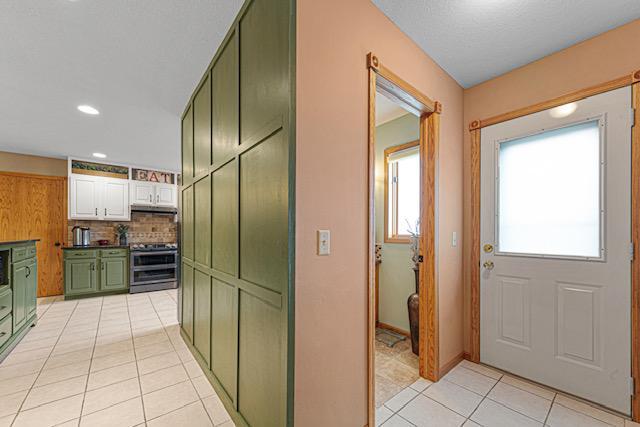 1525 21st Ave NW, Faribault, MN 55021 - kitchen featuring green cabinets, range with two ovens, light tile patterned floors, tasteful backsplash, and recessed lighting