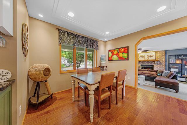 1525 21st Ave NW, Faribault, MN 55021 - dining area with light wood finished floors, recessed lighting, and a fireplace