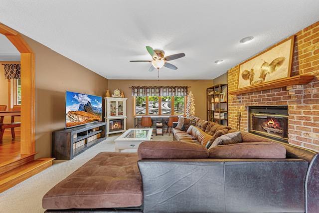 1525 21st Ave NW, Faribault, MN 55021 - living room with a ceiling fan, a fireplace, carpet flooring, and arched walkways