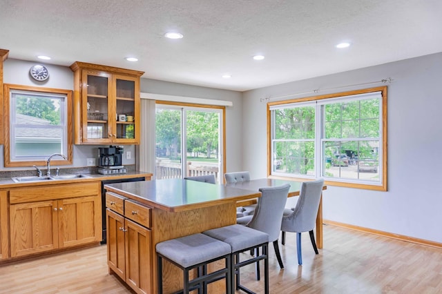 319 Casper Cir, Norwood Young America, MN 55368 - kitchen featuring a sink, a kitchen breakfast bar, light wood-style floors, recessed lighting, and plenty of natural light