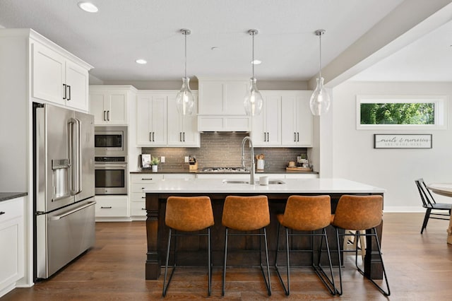 16632 Early Dawn Trl, Lakeville, MN 55044 - kitchen featuring stainless steel appliances, a sink, a breakfast bar, tasteful backsplash, and recessed lighting