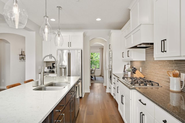 16632 Early Dawn Trl, Lakeville, MN 55044 - kitchen with arched walkways, appliances with stainless steel finishes, a sink, dark brown cabinetry, and white cabinets