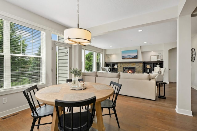 16632 Early Dawn Trl, Lakeville, MN 55044 - dining room with baseboards, a lit fireplace, wood finished floors, and recessed lighting