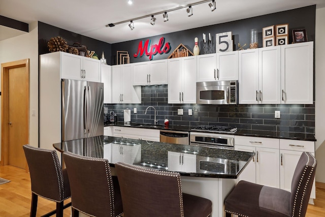 401 2nd St Unit 208, Minneapolis, MN 55401 - kitchen with stainless steel appliances, a sink, a breakfast bar, and white cabinetry