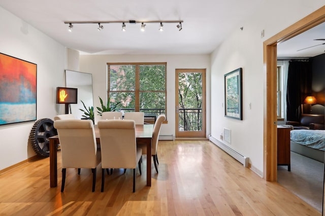 401 2nd St Unit 208, Minneapolis, MN 55401 - dining space with a baseboard heating unit, light wood-type flooring, rail lighting, and baseboards