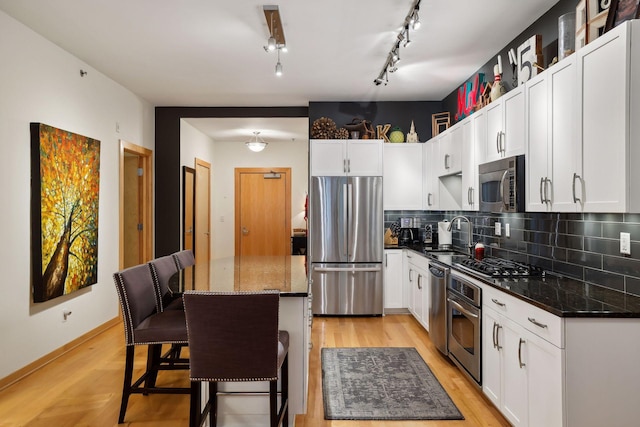 401 2nd St Unit 208, Minneapolis, MN 55401 - kitchen featuring stainless steel appliances, a sink, tasteful backsplash, a kitchen island, and a breakfast bar