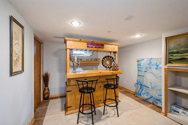 2575 Quebec Ave S, Saint Louis Park, MN 55426 - indoor dry bar featuring a textured ceiling, baseboards, and light tile patterned floors