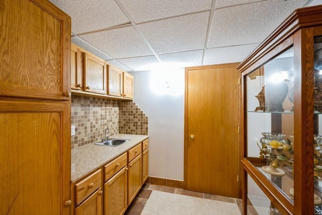 2575 Quebec Ave S, Saint Louis Park, MN 55426 - kitchen featuring a sink, tasteful backsplash, light countertops, a paneled ceiling, and light tile patterned floors
