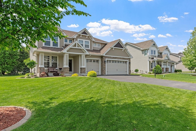 14143 Ailesbury Ave, Rosemount, MN 55068 - craftsman-style house featuring covered porch, asphalt driveway, a front lawn, stone siding, and board and batten siding